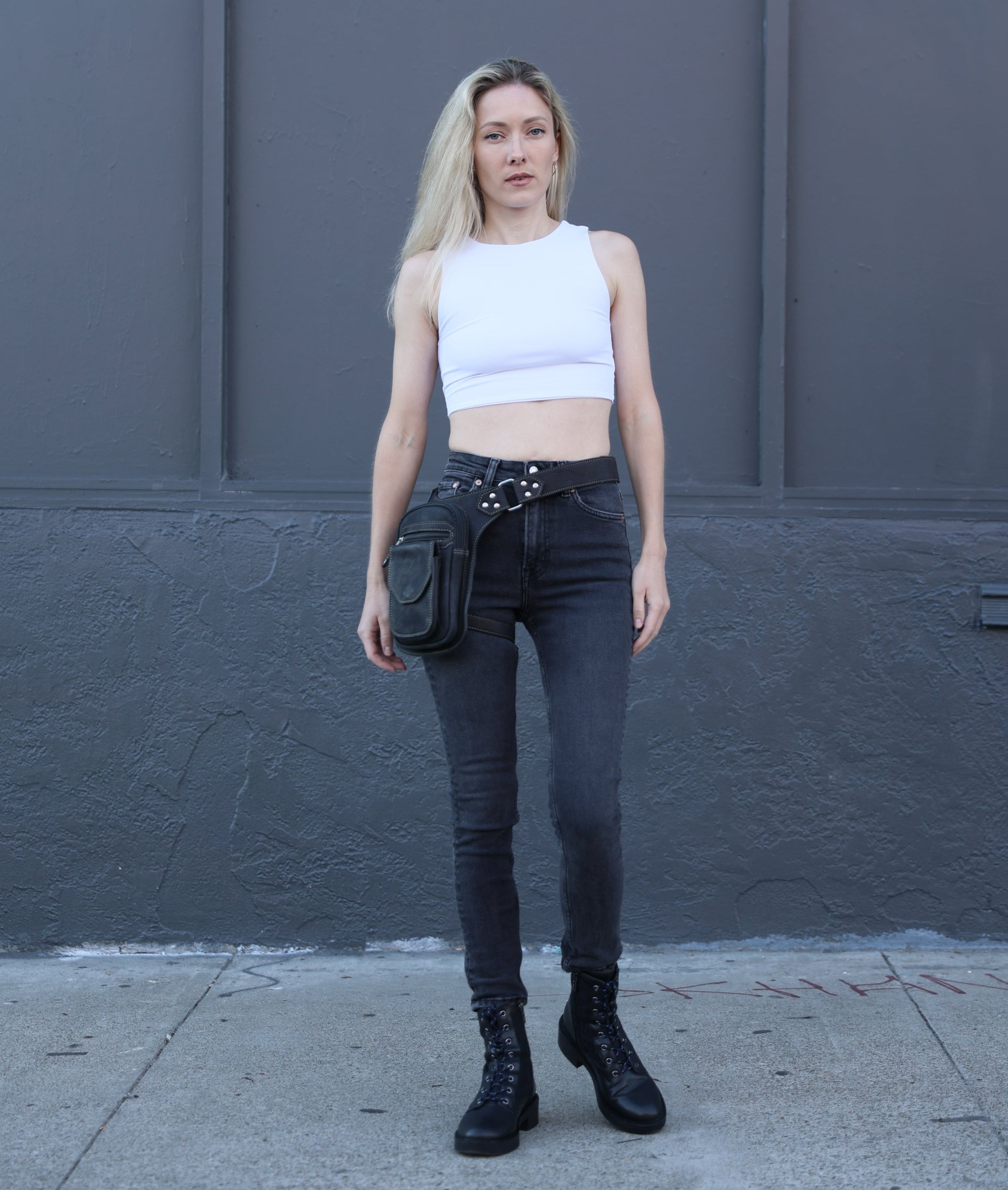 Woman standing wearing a leather leg bag  
