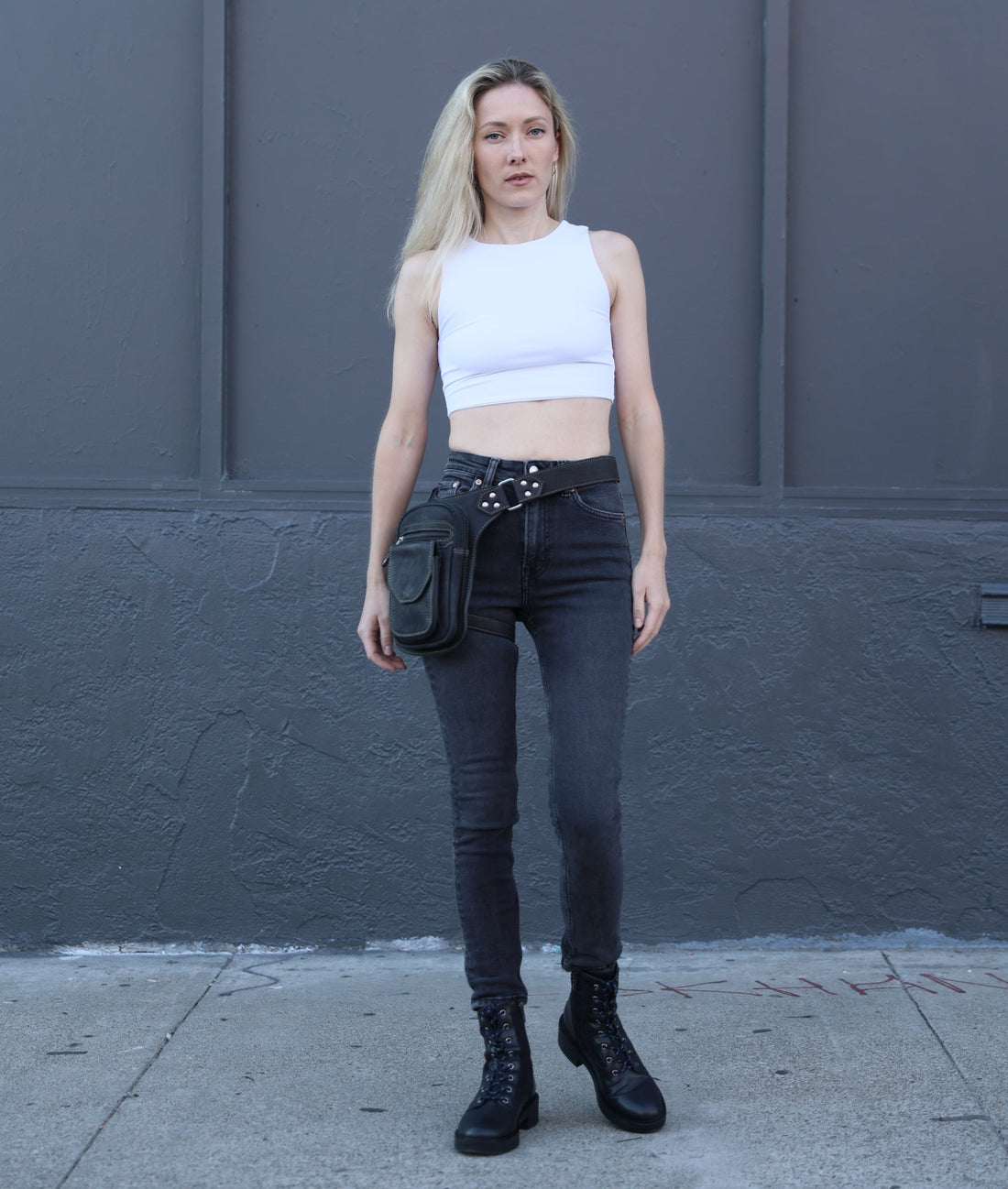 Woman standing wearing a leather leg bag  
