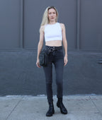 Woman standing wearing a leather leg bag  