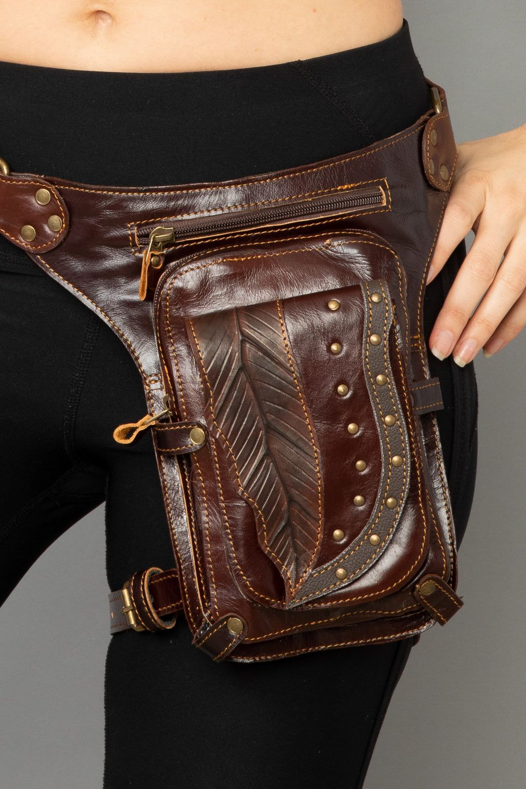 Brown leather holster with decorative elements on a black background