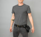 Man staring wearing a black belt against a grey background