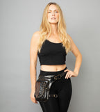 Woman wearing a black leather leg bag against a grey background

