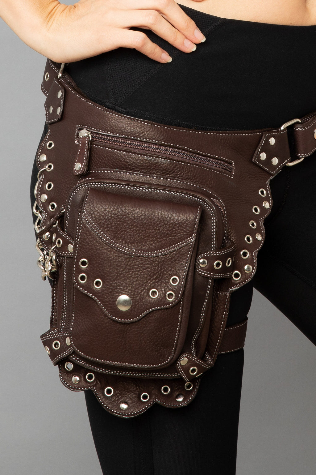 Close up of a studded brown leather hip pouch with leg strap 